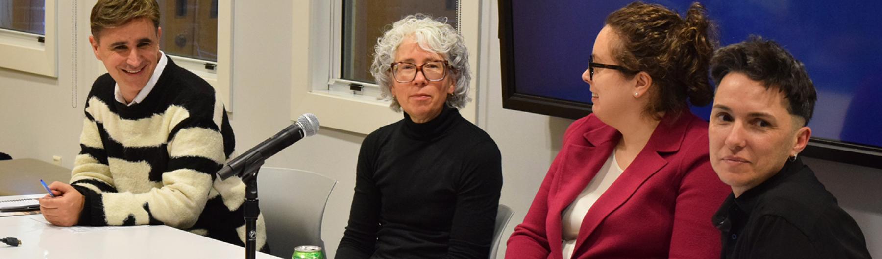 People sitting at a table with a microphone.